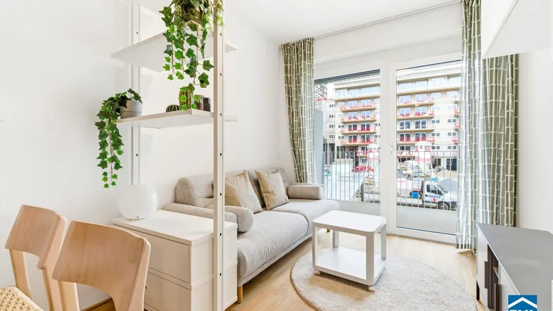 Helles Wohn- und Esszimmer mit Parkettboden, modernen Möbeln und Zugang zum Balkon.
