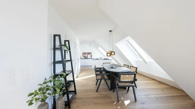 Moderner Essbereich mit Holzboden, Dachschrägen und Oberlichtern, offen zur Küche.