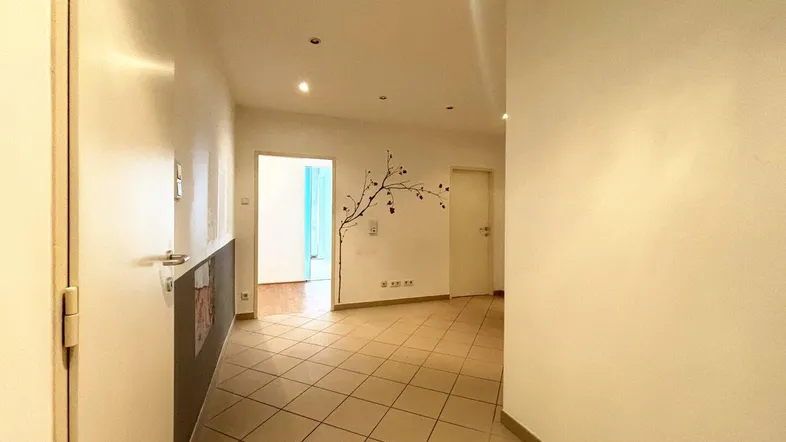 Heller Flur mit Fliesenboden und Zugang zu weiteren Räumen in der Wohnung.