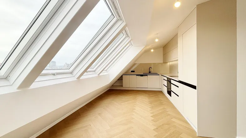 Helle Dachgeschosswohnung mit moderner Einbauküche, Dachfenstern und Fischgrätparkett.