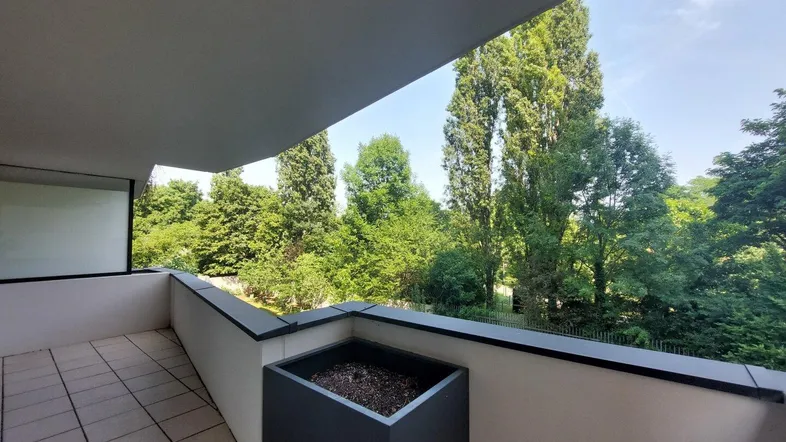 Geräumiger Balkon mit Fliesenboden und einem schönen, weitreichenden Blick ins Grüne.