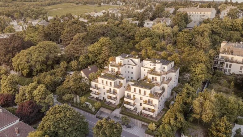 Luftaufnahme eines modernen Wohnkomplexes mit begrünten Dächern und Balkonen in grüner Umgebung.