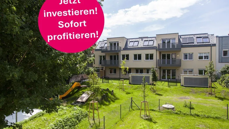 Moderne Wohnanlage mit großzügiger Grünfläche und Kinderspielplatz, ideal für Familien.