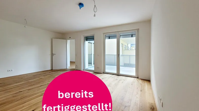 Helles, leeres Zimmer mit Holzboden und Zugang zu einem Balkon, bereit zum Einzug.