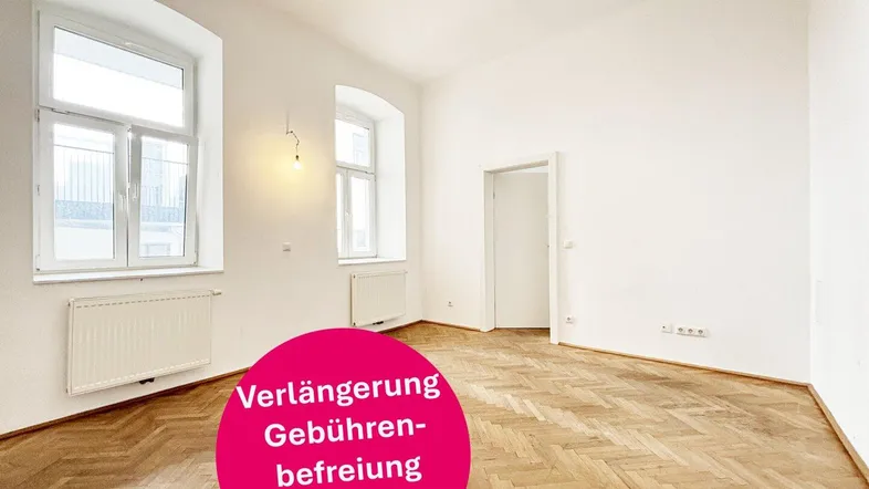 Helles, leeres Zimmer mit Fischgrätparkett und großen Fenstern, bereit zur individuellen Gestaltung.
