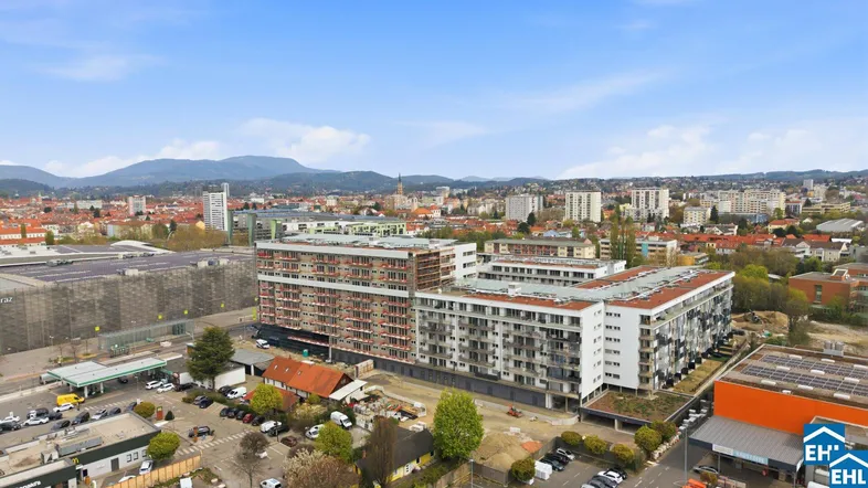 Luftaufnahme eines modernen Wohnkomplexes in städtischer Umgebung mit Bergblick.