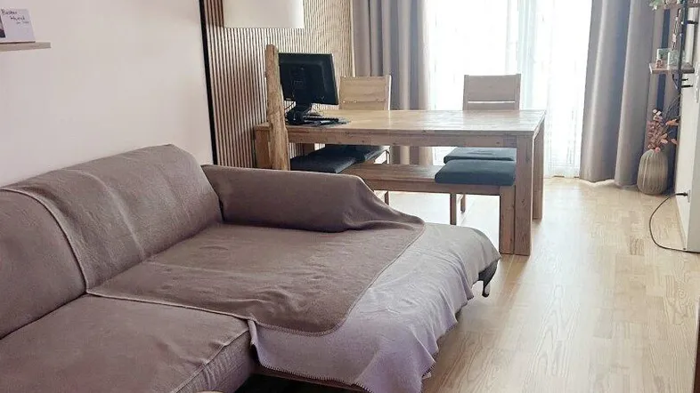 Offener Wohn-Essbereich mit gemütlichem Sofa, Esstisch und hellem Holzfußboden.