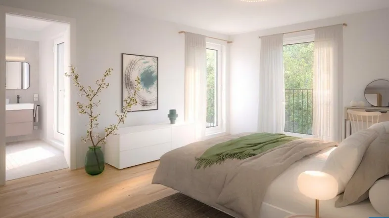 Helles Schlafzimmer mit Holzboden, großen Fenstern und Blick ins Grüne, mit direktem Zugang zum modernen Badezimmer.