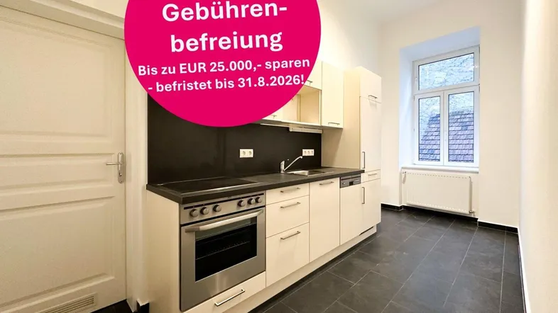 Helle Einbauküche mit modernen Geräten, dunkler Arbeitsplatte und Fliesenboden, bereit zur Nutzung.