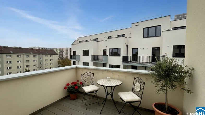 Gemütlicher Balkon mit Sitzgelegenheiten und Blick auf moderne und ältere Gebäude.