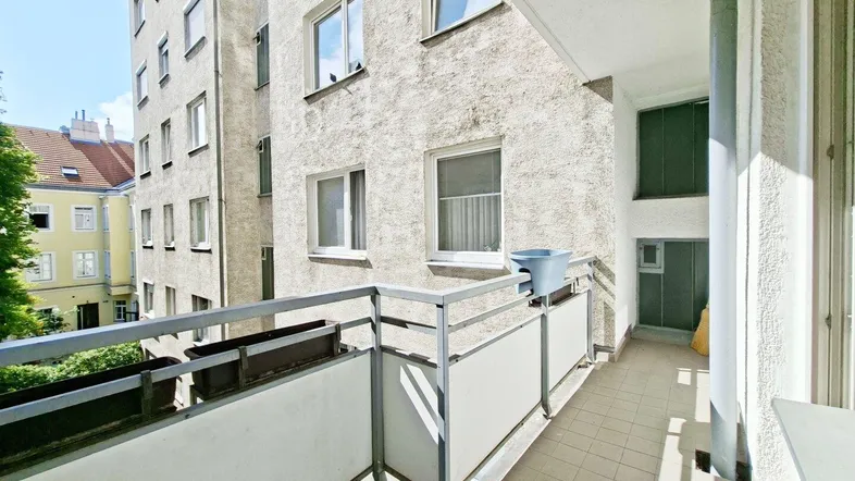 Schmaler Balkon mit Metallgeländer und Blick auf die umliegenden Gebäude.