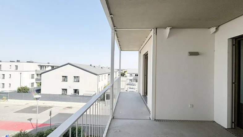 Geräumiger Balkon mit Blick auf die umliegenden Gebäude und viel Tageslicht.