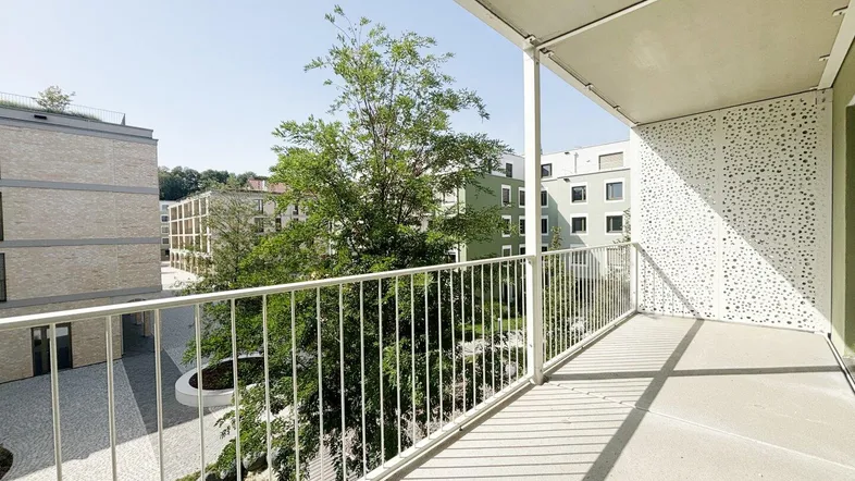Geräumiger Balkon mit Blick auf die umliegenden Neubauten und grüne Innenhöfe.