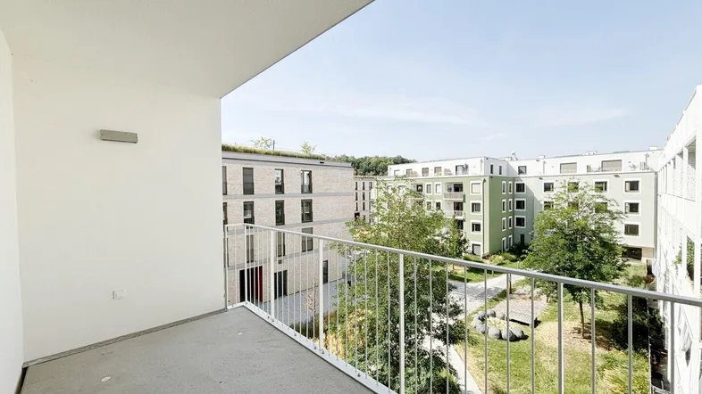 Geräumiger Balkon mit Blick auf die umliegenden modernen Wohngebäude und Grünflächen.