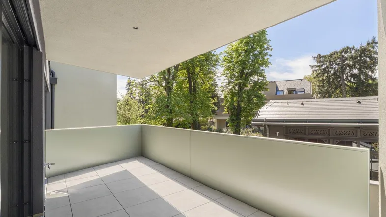 Geräumiger Balkon mit hellem Fliesenboden und weitem Blick ins Grüne.