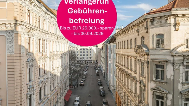 Blick auf eine historische Straße mit eleganten Altbauten und parkenden Autos in einer städtischen Umgebung.