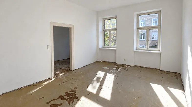 Heller Raum in Renovierungszustand mit zwei Fenstern und viel Tageslicht, bereit für neue Gestaltung.