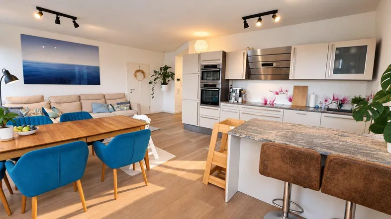 Moderne offene Küche mit Essbereich und Wohnzimmer, ausgestattet mit Holzboden und Kücheninsel.