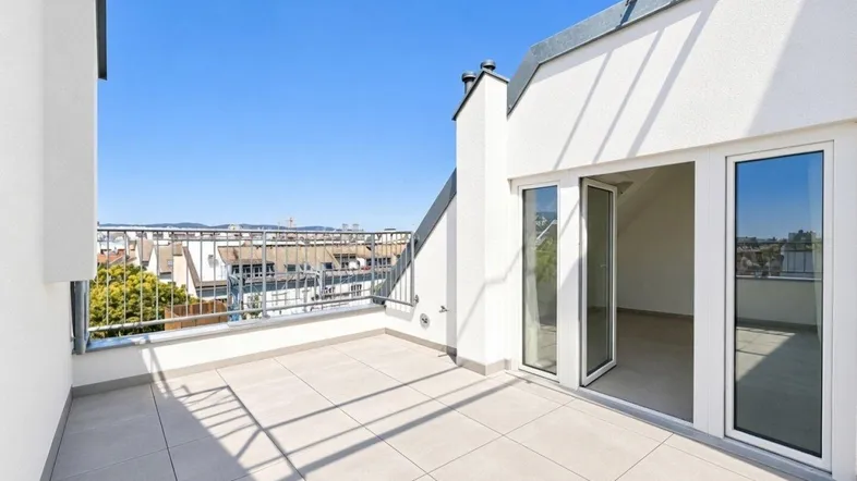 Große, leere Dachterrasse mit weitem Blick über die Stadt unter blauem Himmel.