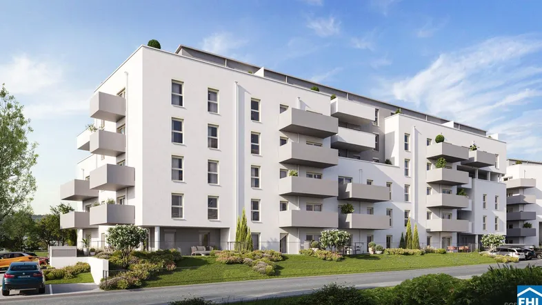 Moderne Wohnanlage mit weißer Fassade und zahlreichen Balkonen unter blauem Himmel.