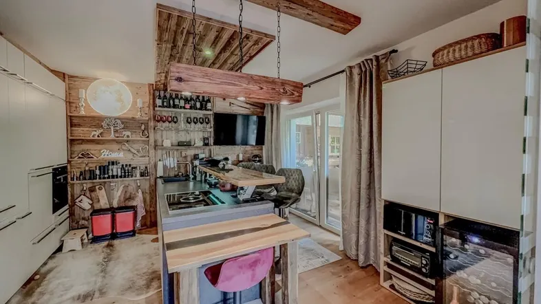 Moderne Küche mit Holzelementen, Kochinsel und integrierten Geräten, ideal für gesellige Abende.