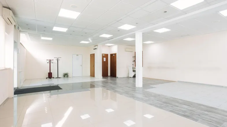 Geräumiger, heller Büroraum mit modernen Fliesenböden und abgehängter Decke, ideal für verschiedene Geschäftsnutzungen.