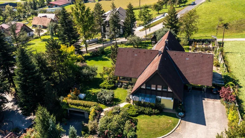 Luftaufnahme eines Einfamilienhauses mit großem Garten und ländlicher Umgebung.