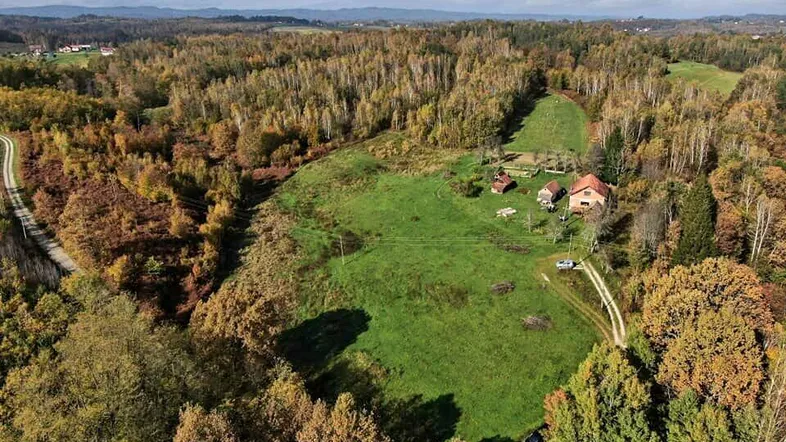 Luftaufnahme des Anwesens mit weitläufigen Feldern, Wald und mehreren Gebäuden in ländlicher Umgebung.