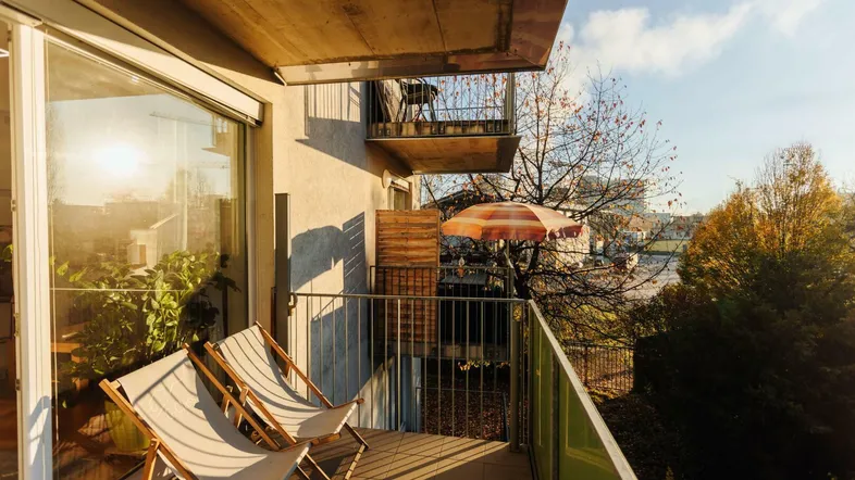 Sonniger Balkon mit Liegestühlen und Blick auf die Umgebung, ideal zum Entspannen im Freien.