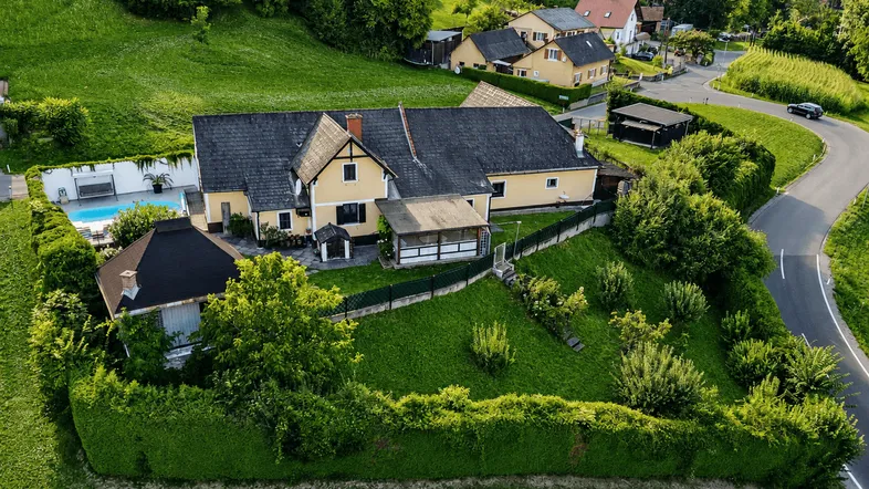 Luftaufnahme des Anwesens mit großem Garten, Pool und umliegender grüner Landschaft.