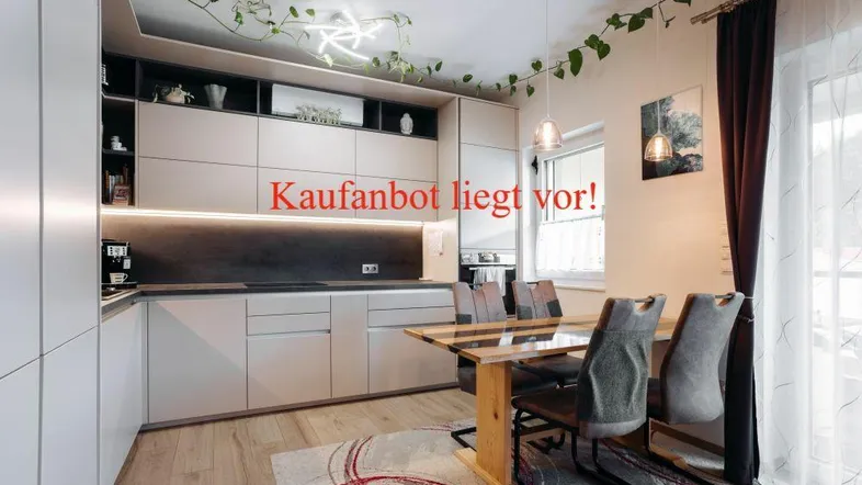 Moderne Einbauküche mit Essbereich, hellen Fronten, Holzboden und viel Tageslicht.