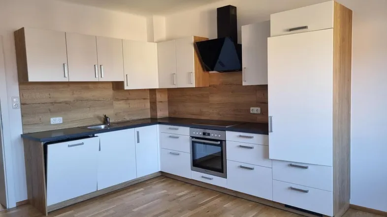 Moderne Einbauküche mit weißen Fronten, Holzoptik-Rückwand und integrierten Geräten.