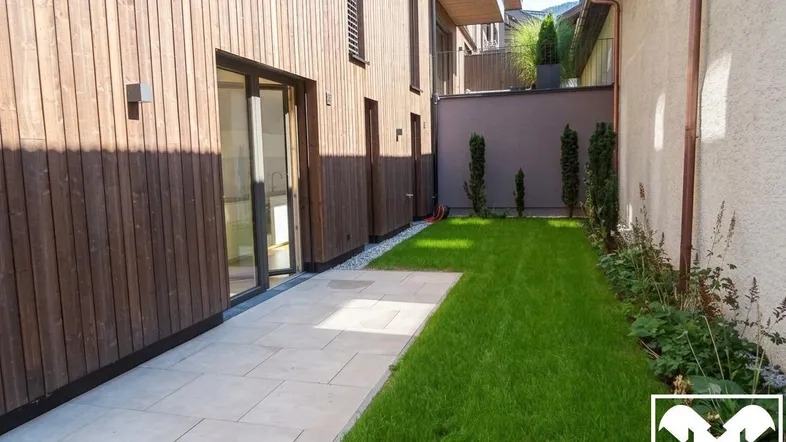 Private Gartenfläche mit gepflasterter Terrasse und Zugang zu den Innenräumen des Gebäudes.