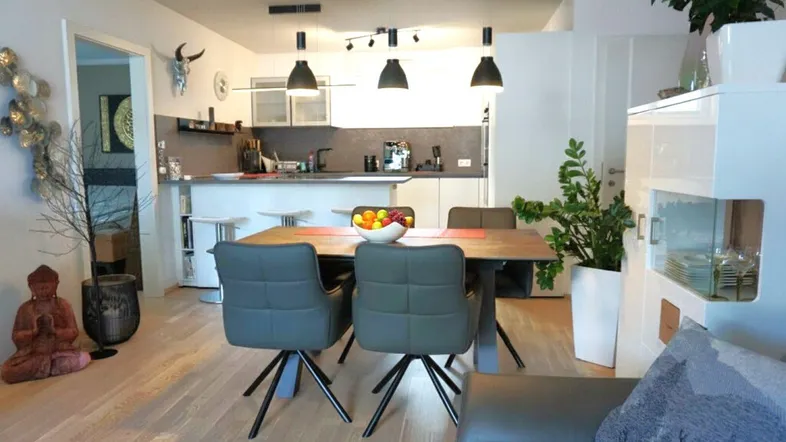 Moderne offene Küche mit Essbereich, Holzboden und stilvoller Beleuchtung.