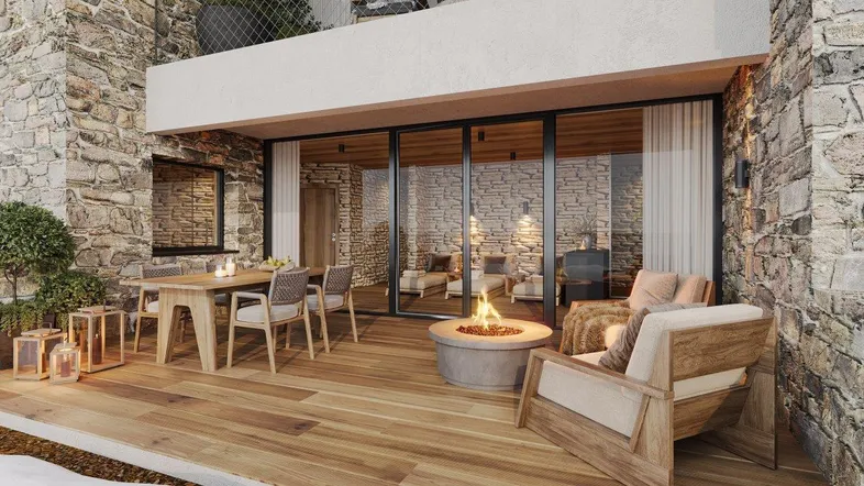 Große Holzterrasse mit Sitzgelegenheiten, Feuerstelle und Steinmauer, ideal für entspannte Abende im Freien.