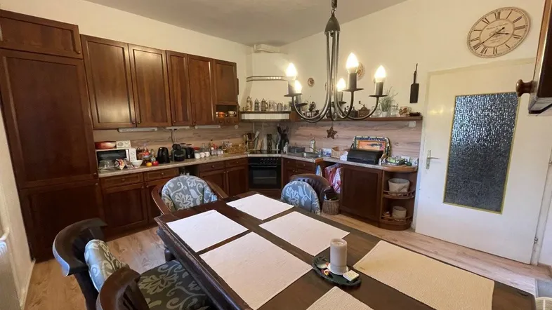 Geräumige Wohnküche mit Holzeinbauten, großem Esstisch und traditionellem Charme.