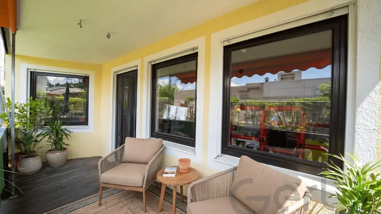 Gemütlicher Balkon mit Sitzgelegenheiten und Pflanzen, ideal zum Entspannen im Freien.