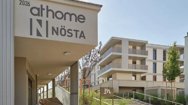 Moderne Wohnanlage mit barrierefreiem Zugang, Treppen und einem weiteren Gebäude im Hintergrund.