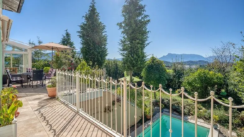 Große Terrasse mit Garten, kleinem Pool und Panoramablick auf Berge und See.