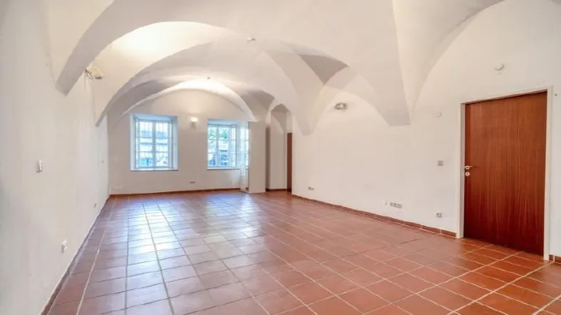 Geräumiger Innenraum mit beeindruckender Gewölbedecke, Terrakottafliesen und natürlichem Lichteinfall.