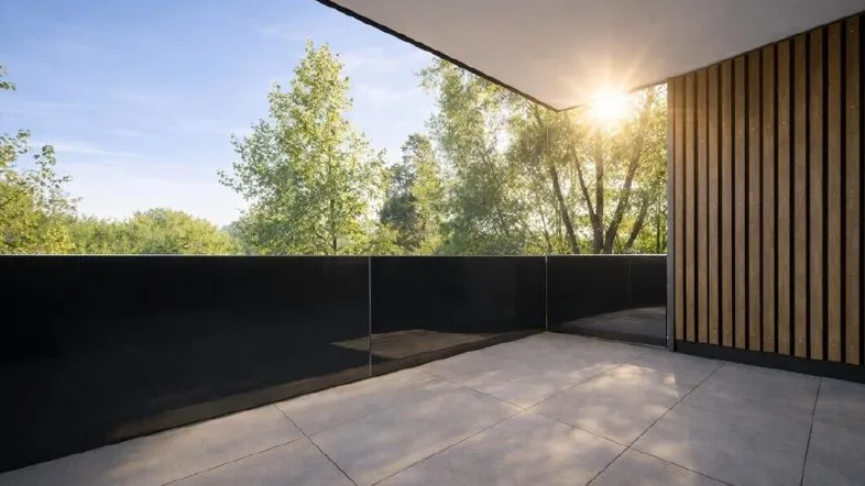 Sonnige Terrasse mit modernem Design, Holzwand und Blick ins Grüne.