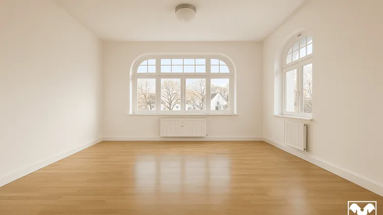 Heller, leerer Raum mit Holzboden und großen, bogenförmigen Fenstern, die viel Tageslicht hereinlassen.