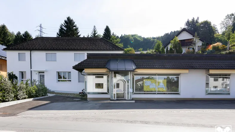Ansicht des Gebäudes mit einem kommerziellen Erdgeschoss und einem Wohnbereich im Obergeschoss.