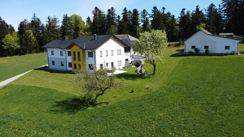 Großzügiges Anwesen mit modernem Wohnhaus und weitläufigen Grünflächen in ländlicher Umgebung.