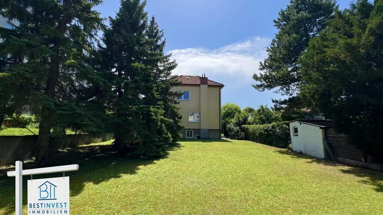 Das Haus steht auf einem weitläufigen Grundstück mit altem Baumbestand und einem kleinen Gartenhaus.
