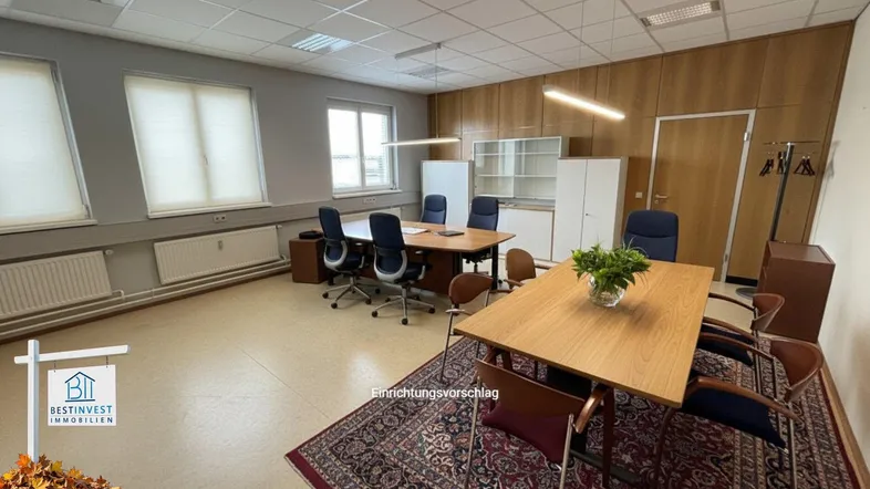 Geräumiges Büro mit Holzvertäfelung, mehreren Arbeitsplätzen und einem Besprechungstisch.