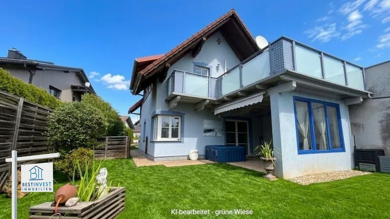 Freistehendes Einfamilienhaus mit Garten, Balkon und Terrasse unter blauem Himmel.