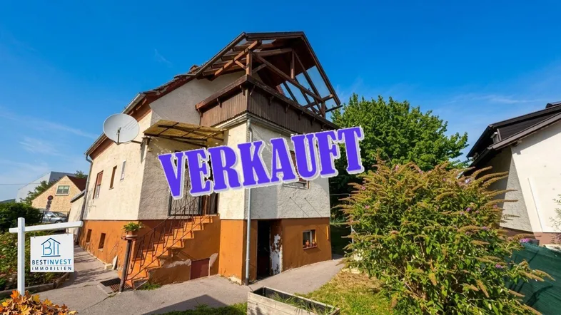 Älteres Einfamilienhaus mit Satteldach und sichtbarer Holzkonstruktion im Dachbereich.