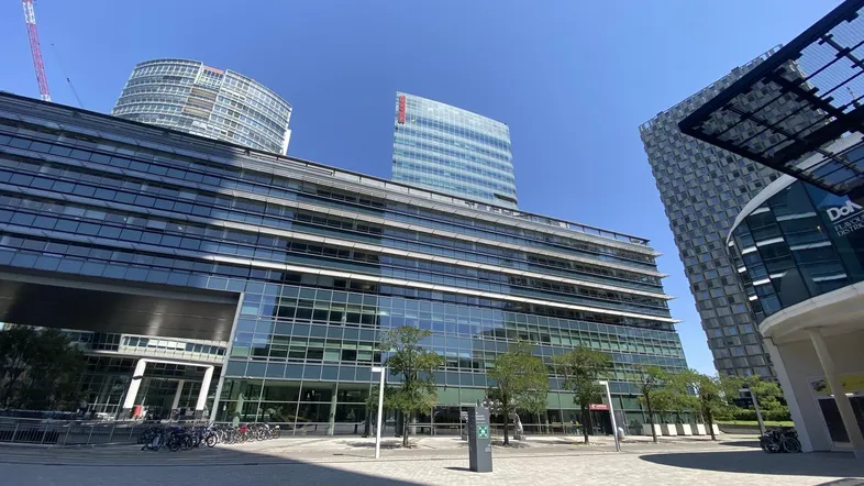 Moderne Bürogebäude mit Glasfassaden und klarem Himmel an einem sonnigen Tag.