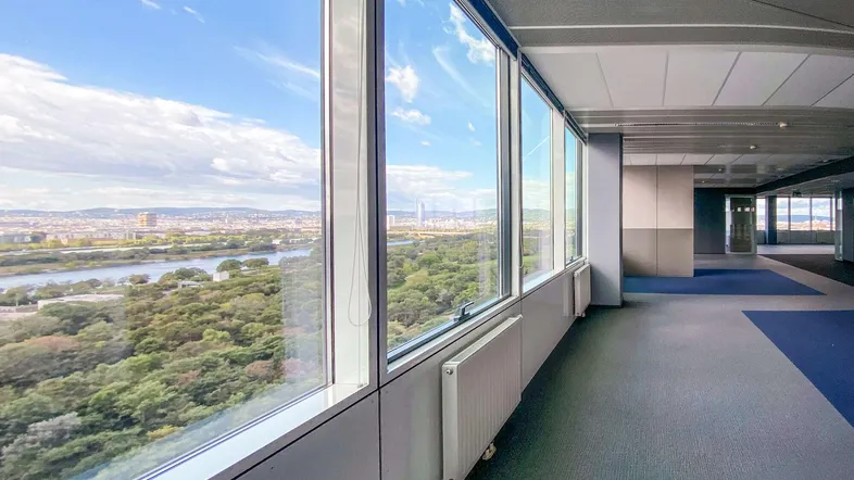 Geräumiges Büro mit großen Fenstern bietet einen weiten Blick auf die Stadt und die umliegende Natur.